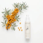 A flat lay photograph on a white background showing a 50ml bottle of BOTANĒ Retinol Alternative Moisturiser next to a fresh sea buckthorn branch with vibrant orange berries. thumbnail 2