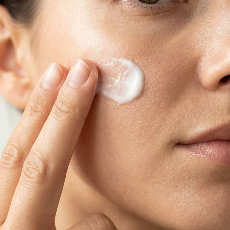 Close-up of applying a creamy BOTANĒ face cream to the cheek for a gentle natural skincare routine. product image