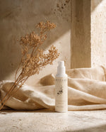 BOTANĒ Retinol Alternative Moisturiser pump bottle on textured stone with draped linen and dried flowers in warm sunlight. thumbnail 1